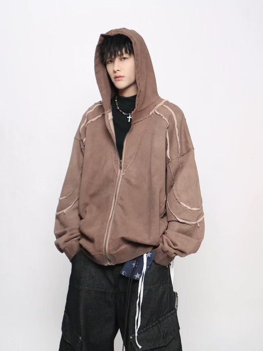 Person wearing a brown hoodie with white accents on a plain background