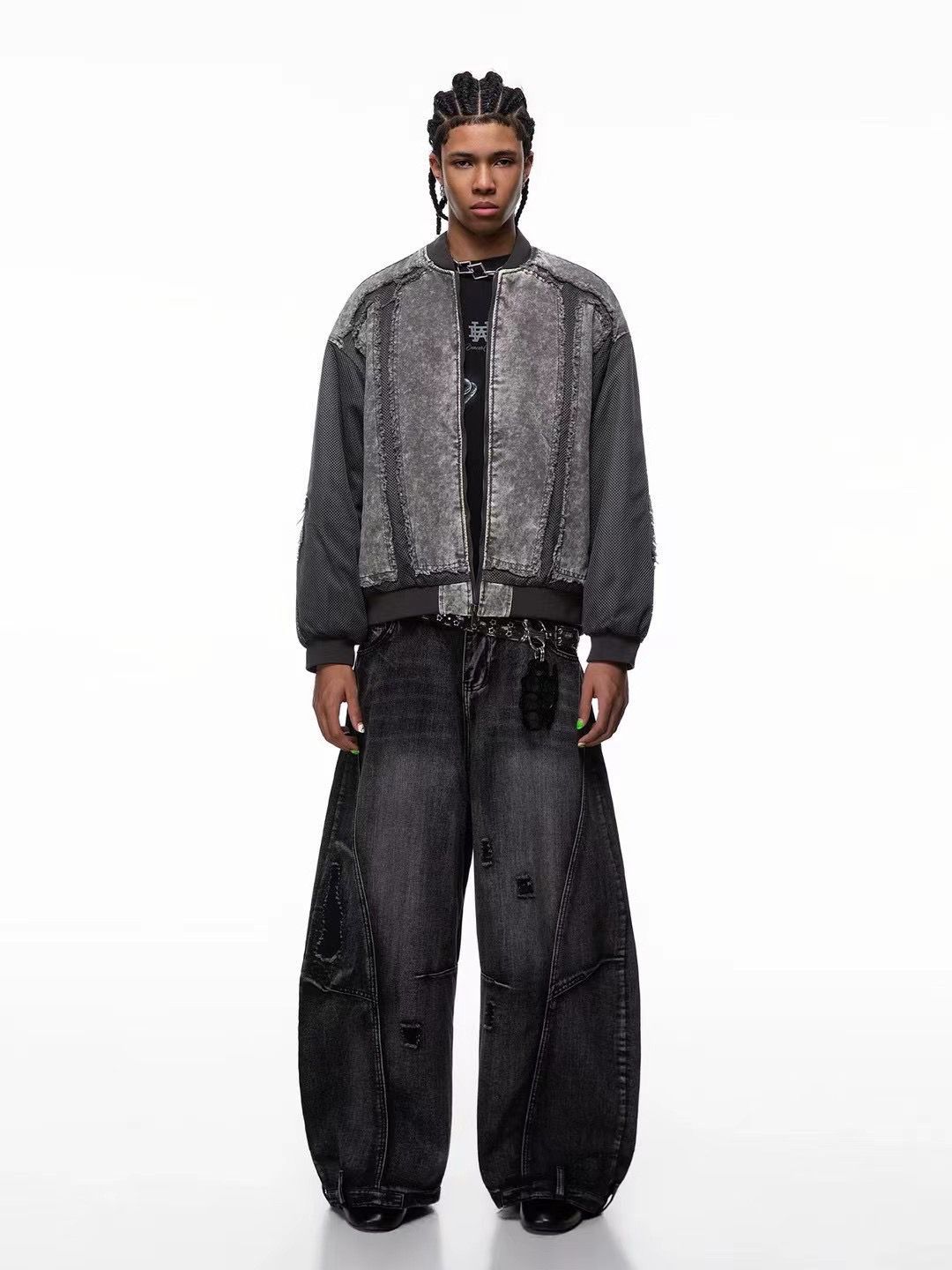 Person wearing a gray textured jacket and black pants on a white background