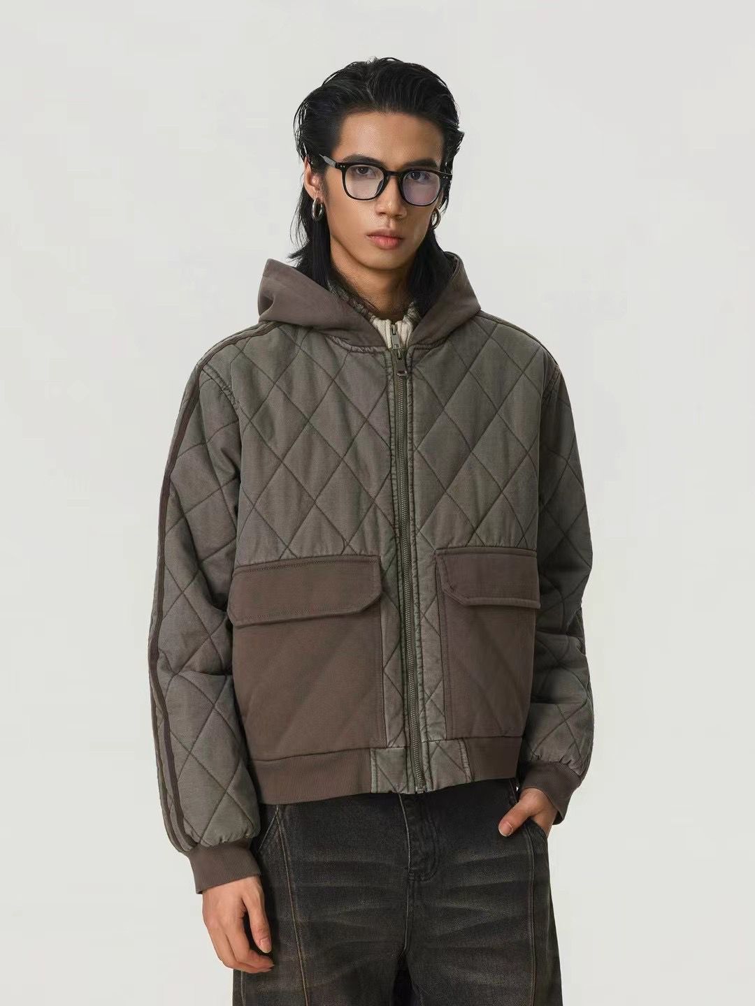 Person wearing a quilted jacket with a plain background